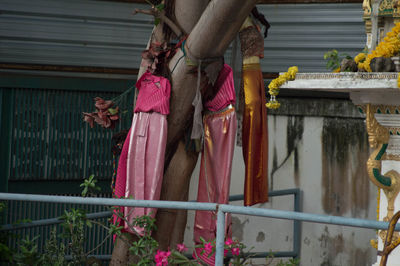 Woman standing by railing of flowering plants