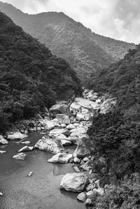 Scenic view of river amidst mountains against sky