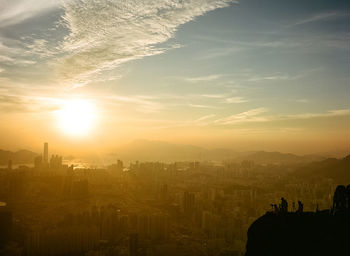 Aerial view of buildings in city against sky during sunset