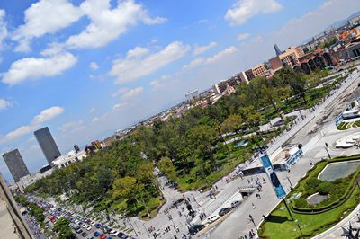 High angle view of trees and buildings in city against sky