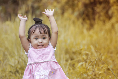 Portrait of cute girl standing on field