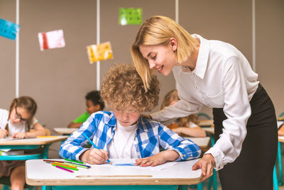 Teacher teaching student at classroom