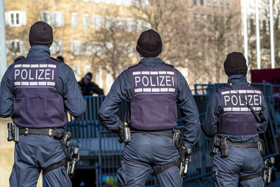 Rear view of men with people in background