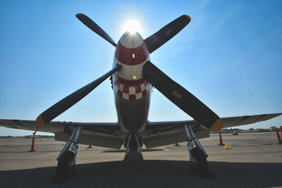 Airplane on airport runway against sky