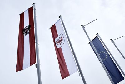 Low angle view of flags hanging against sky