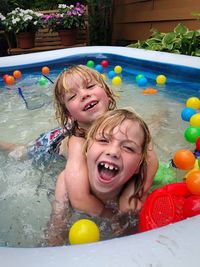 Portrait of sisters swimming in wading pool
