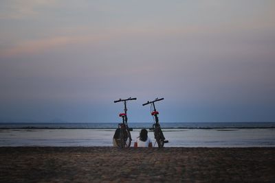 People on beach against sky during sunset