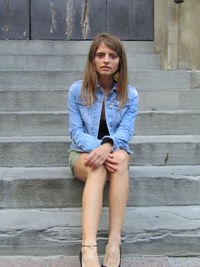 Portrait of a beautiful young woman sitting on staircase