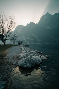 Scenic view of lake by mountains against sky