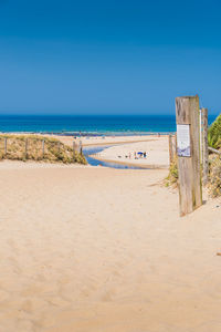 Scenic view of beach against clear blue sky