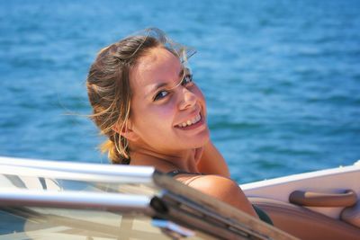 Portrait of smiling young woman in boat at sea