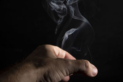 Close-up of person hand against black background