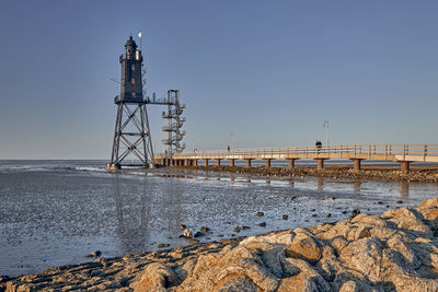 Tower on beach against clear sky