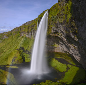 Scenic view of waterfall against sky