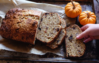 Cropped hand having bread on table