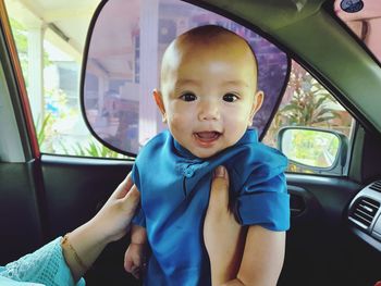 Portrait of cute boy smile sitting in car