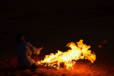 Man sitting with fire crackers at night