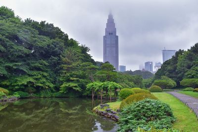 Scenic view of river by buildings against sky