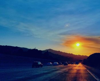 Cars on road at sunset