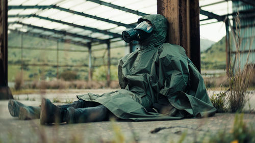 Soldier with gas mask is resting on the ground