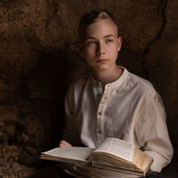 Portrait of young man reading book
