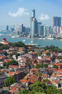 Aerial view of buildings in city against sky