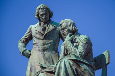 Low angle view of statue against clear blue sky