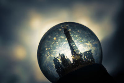 Close-up of crystal ball against sky