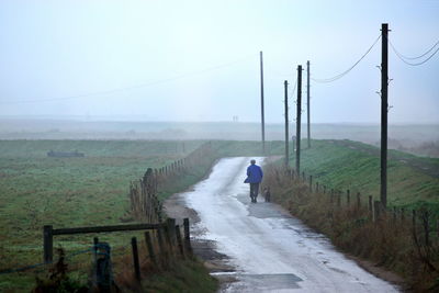 Rear view of people walking on footpath