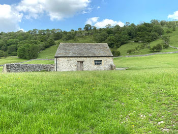 Landscape, with an old stone barn, in a large field, with trees in, kettlewell, skipton, uk