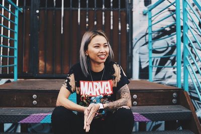 Portrait of smiling young woman sitting on bench