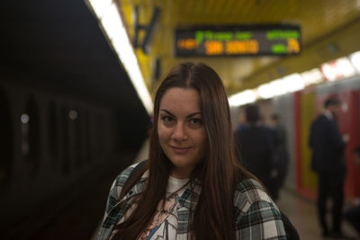 Portrait of smiling young woman at railroad station