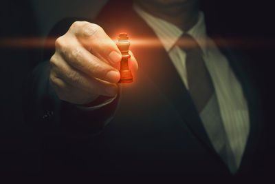 Close-up of hand holding lit candle