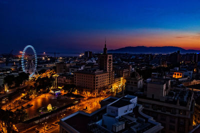 High angle view of illuminated cityscape against clear sky