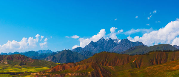 Panoramic view of landscape and mountains against blue sky