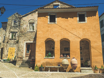 People in old building against sky in city