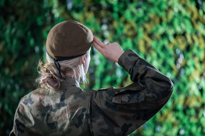 A woman in uniform and wearing a beret salutes. temporary military barracks. 