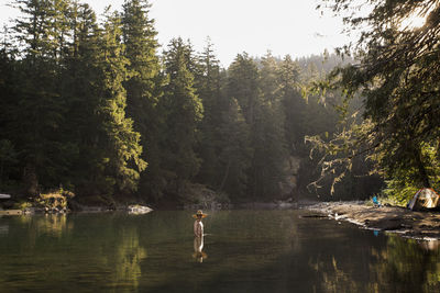 A young man wades into the ohanapecosh river in washington.