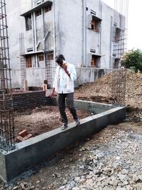 Full length of woman standing at construction site in city