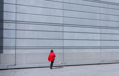 Full length of woman standing against wall
