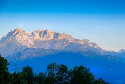 Scenic view of snowcapped mountains against clear blue sky