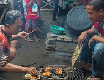 People having food at market