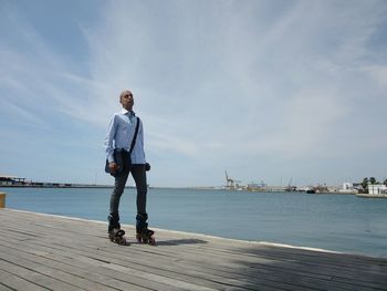 Full length of man inline skating against sea