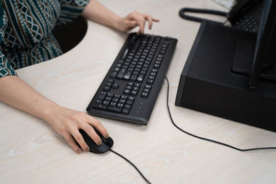 Midsection of woman using smart phone on table