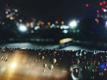 Close-up of wet illuminated city at night