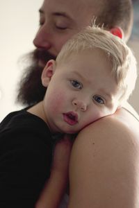 Portrait of cute baby boy with father at home