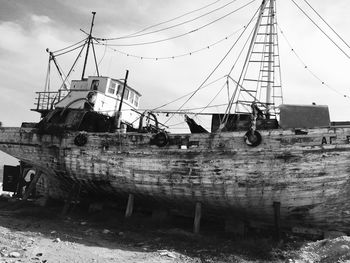 Abandoned ship in water against sky