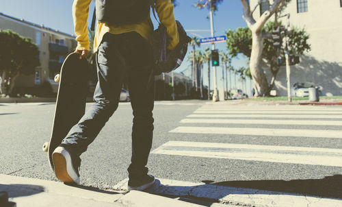 Low section of people walking on city street