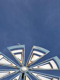 Low angle view of mill blades  against sky