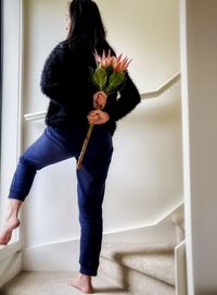 Low section of woman standing against wall